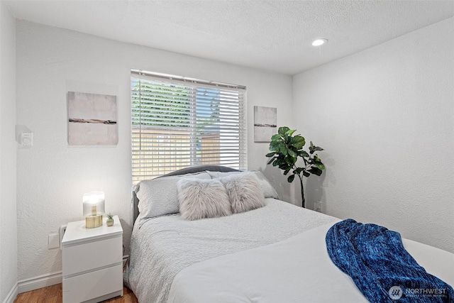 14600 SE 176th St Unit H11, Renton, WA 98058 - bedroom featuring wood finished floors, baseboards, a textured ceiling, recessed lighting, and a textured wall