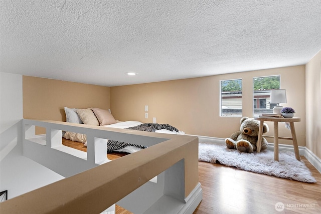 14600 SE 176th St Unit H11, Renton, WA 98058 - bedroom with wood finished floors, a textured ceiling, and baseboards