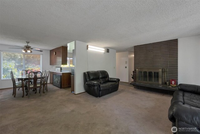 6201 47th Ave S, Seattle, WA 98118 - carpeted living room with a textured ceiling, a tiled fireplace, and a ceiling fan