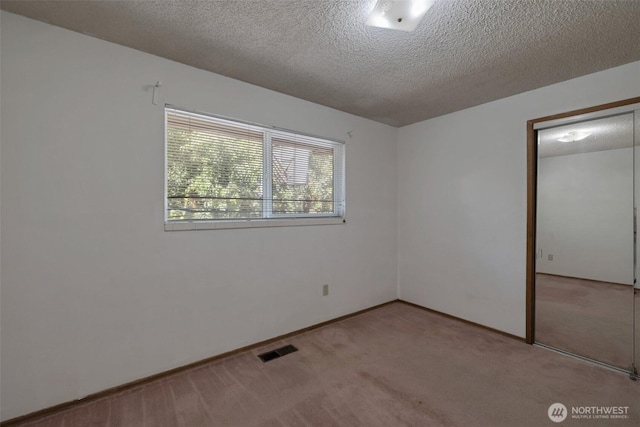 6201 47th Ave S, Seattle, WA 98118 - unfurnished bedroom featuring carpet, a textured ceiling, baseboards, and a closet