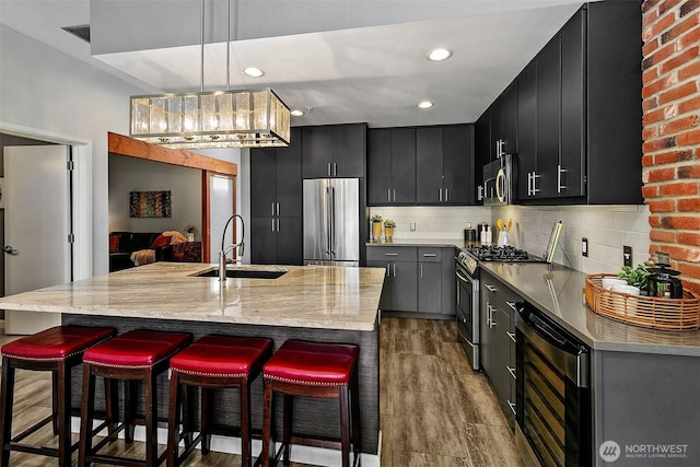 17 W Mercer St Unit 302, Seattle, WA 98119 - kitchen with appliances with stainless steel finishes, dark cabinets, a sink, wine cooler, and recessed lighting