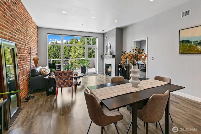 17 W Mercer St Unit 302, Seattle, WA 98119 - dining room with a glass covered fireplace, wood finished floors, recessed lighting, and baseboards