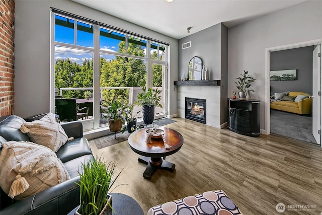 17 W Mercer St Unit 302, Seattle, WA 98119 - living area featuring a glass covered fireplace, wood finished floors, and baseboards