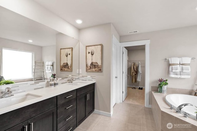 3905 98th Avenue Ct E Unit 33, Edgewood, WA 98371 - bathroom with tile patterned floors, a bath, double vanity, a walk in closet, and recessed lighting