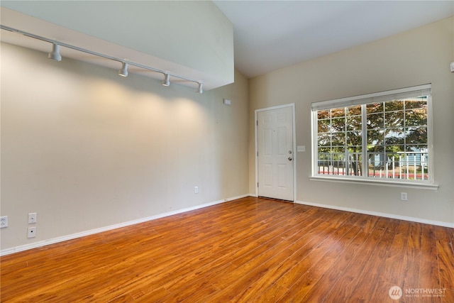 10513 SE 250th Pl Unit F-106, Kent, WA 98031 - spare room featuring rail lighting, wood finished floors, and lofted ceiling