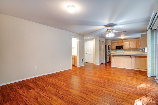 10513 SE 250th Pl Unit F-106, Kent, WA 98031 - kitchen with freestanding refrigerator, a breakfast bar, wood finished floors, ceiling fan, and stove