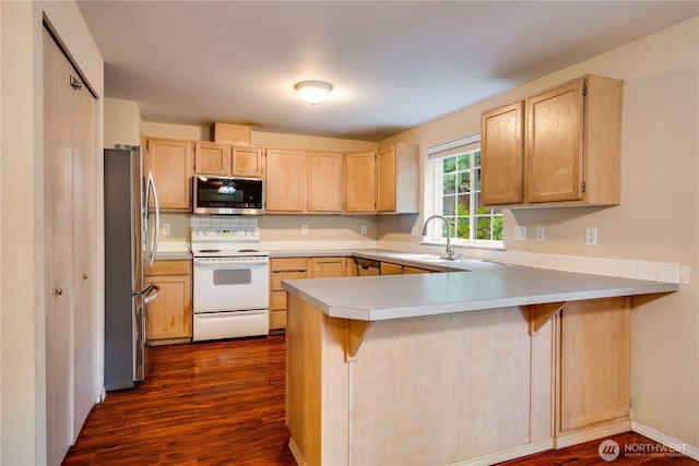 10513 SE 250th Pl Unit F-106, Kent, WA 98031 - kitchen featuring stainless steel appliances, a peninsula, light brown cabinets, dark wood-style floors, and light countertops