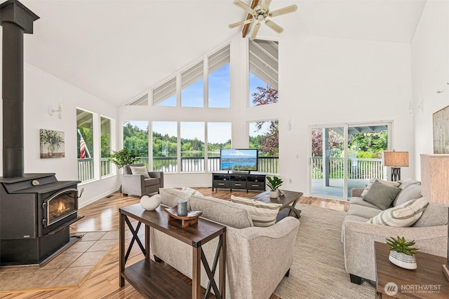 8471 E Caraway Rd, Port Orchard, WA 98366 - living area with high vaulted ceiling, healthy amount of natural light, a wood stove, a ceiling fan, and light wood-type flooring