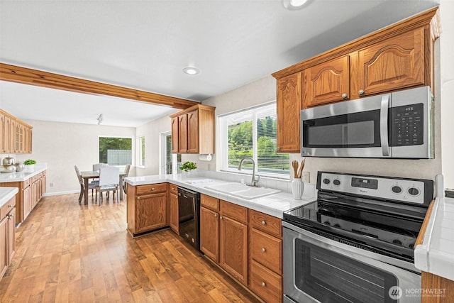 8471 E Caraway Rd, Port Orchard, WA 98366 - kitchen featuring appliances with stainless steel finishes, a sink, light wood-type flooring, tile countertops, and brown cabinets