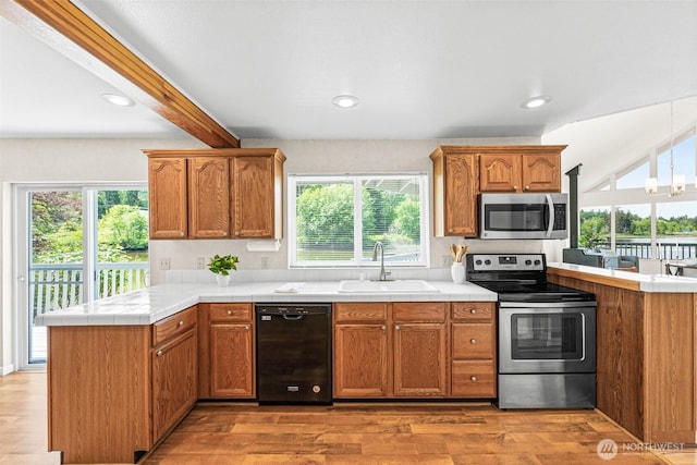 8471 E Caraway Rd, Port Orchard, WA 98366 - kitchen with appliances with stainless steel finishes, a sink, a peninsula, light wood-style floors, and beamed ceiling