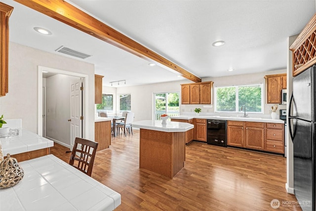 8471 E Caraway Rd, Port Orchard, WA 98366 - kitchen featuring appliances with stainless steel finishes, a sink, tile counters, wood finished floors, and beam ceiling