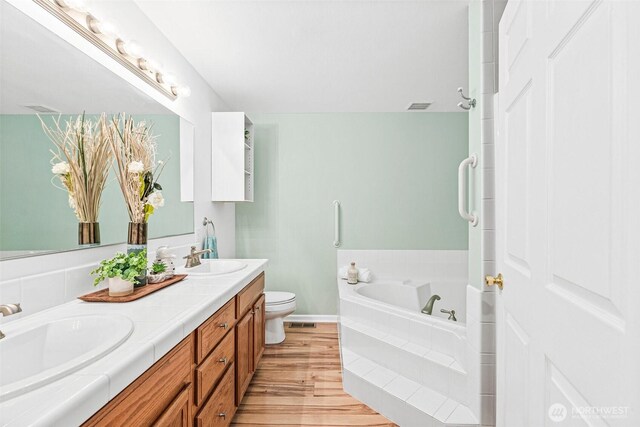 8471 E Caraway Rd, Port Orchard, WA 98366 - full bath featuring double vanity, a garden tub, wood finished floors, toilet, and baseboards