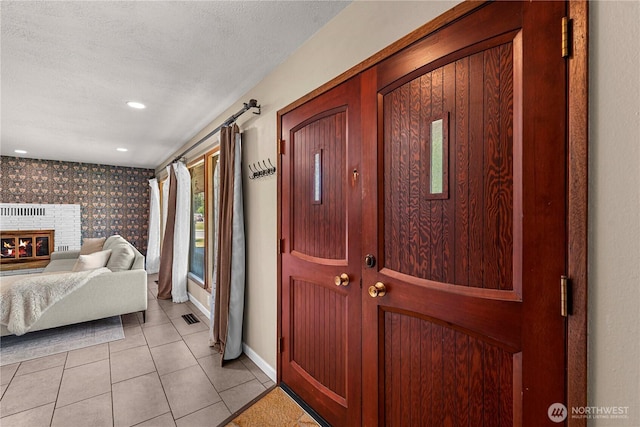 1011 Idaho St, Wenatchee, WA 98801 - entryway with light tile patterned floors, baseboards, a brick fireplace, a textured ceiling, and recessed lighting