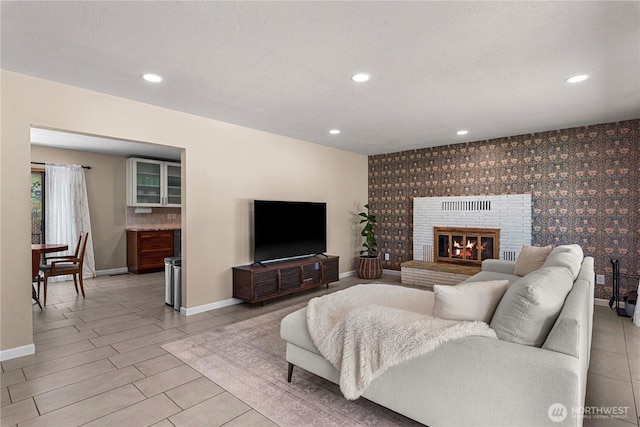 1011 Idaho St, Wenatchee, WA 98801 - living area with baseboards, an accent wall, recessed lighting, wallpapered walls, and a textured ceiling