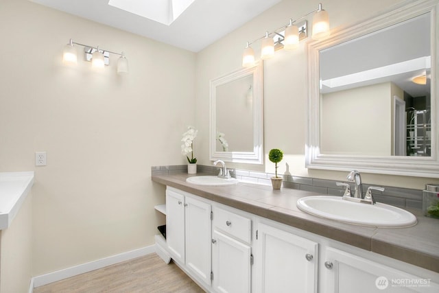4754 SW 314th Pl, Federal Way, WA 98023 - full bathroom featuring a skylight, double vanity, wood finished floors, and baseboards