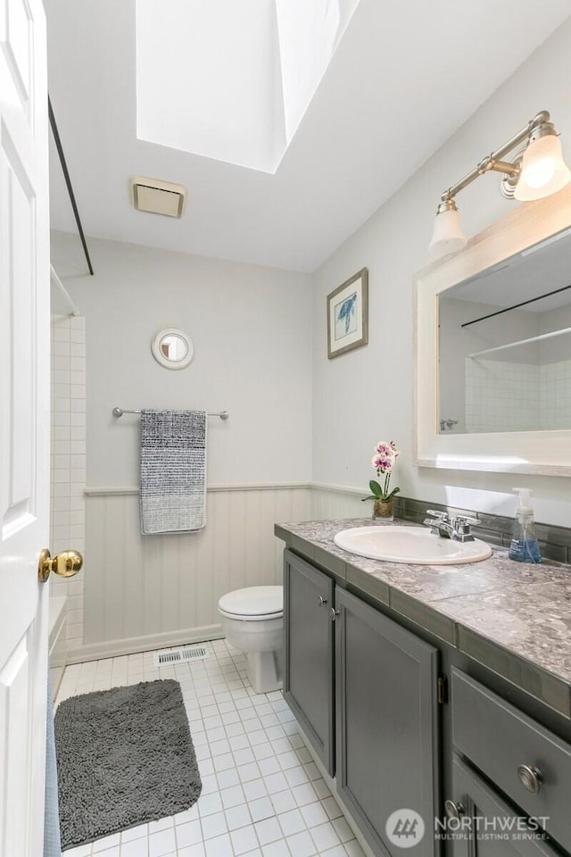 4754 SW 314th Pl, Federal Way, WA 98023 - full bath with vanity, toilet, a wainscoted wall, tile patterned flooring, and a skylight