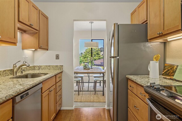 2858 32nd Ave W Unit 302, Seattle, WA 98199 - kitchen with appliances with stainless steel finishes, dark wood-style flooring, a sink, light stone counters, and baseboards