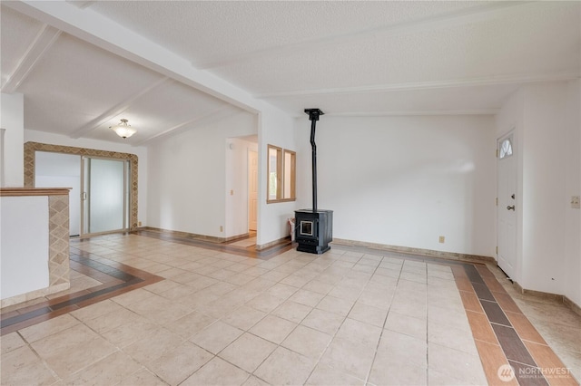 19920 67th Ave NE Unit 40, Arlington, WA 98223 - empty room with inlaid floor details, light tile patterned floors, baseboards, a wood stove, and a textured ceiling