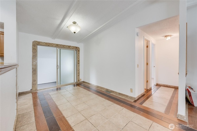 19920 67th Ave NE Unit 40, Arlington, WA 98223 - spare room featuring inlaid floor details, a textured ceiling, baseboards, and light tile patterned floors