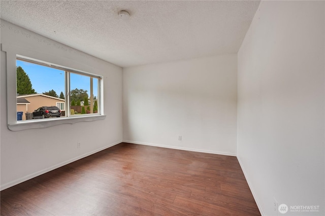 19920 67th Ave NE Unit 40, Arlington, WA 98223 - empty room with wood finished floors, a smoke detector, baseboards, and a textured ceiling