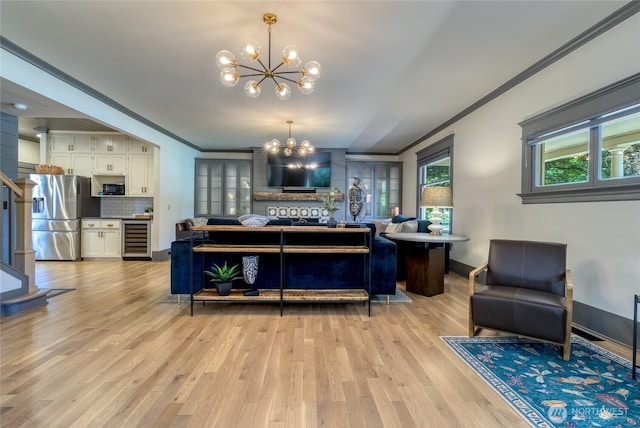 366 S Palouse St, Walla Walla, WA 99362 - living room featuring a chandelier, beverage cooler, crown molding, light wood-style flooring, and baseboards