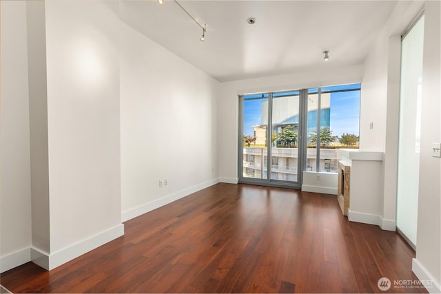 737 Olive Way Unit 2704, Seattle, WA 98101 - spare room featuring dark wood-style flooring and rail lighting
