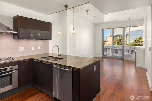 737 Olive Way Unit 2704, Seattle, WA 98101 - kitchen with appliances with stainless steel finishes, wall chimney range hood, dark brown cabinetry, dark stone counters, and dark wood-type flooring