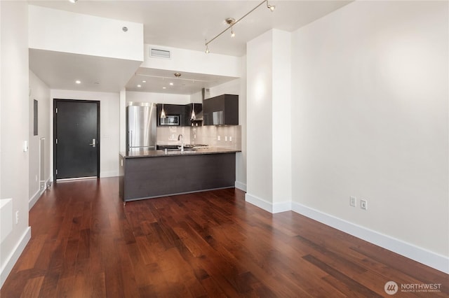 737 Olive Way Unit 2704, Seattle, WA 98101 - kitchen featuring stainless steel appliances, a peninsula, dark wood-style flooring, tasteful backsplash, and rail lighting