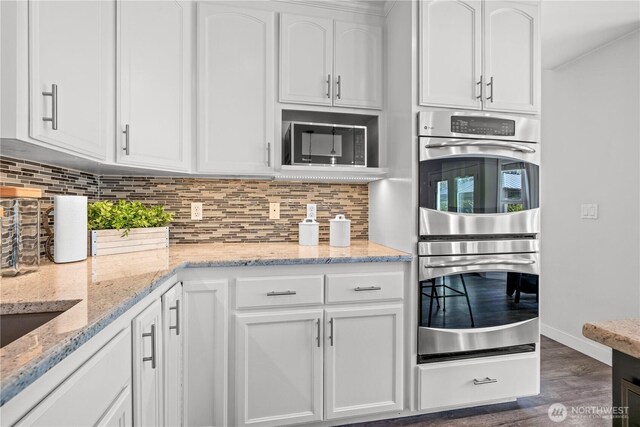 28314 164th Ave E, Graham, WA 98338 - kitchen with double oven, white cabinetry, black microwave, and dark wood-style floors