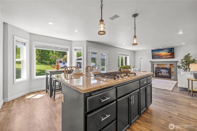 28314 164th Ave E, Graham, WA 98338 - kitchen featuring stainless steel gas stovetop, a tiled fireplace, light wood finished floors, hanging light fixtures, and recessed lighting