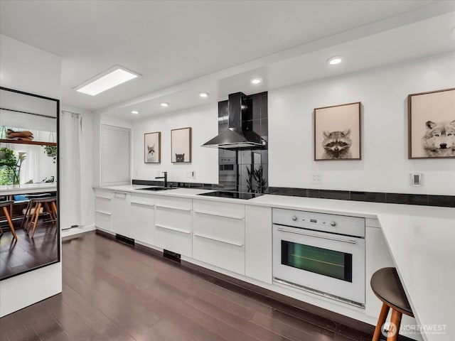 13893 NE 69th St Unit 689, Redmond, WA 98052 - kitchen featuring oven, modern cabinets, wall chimney range hood, black electric stovetop, and white cabinets