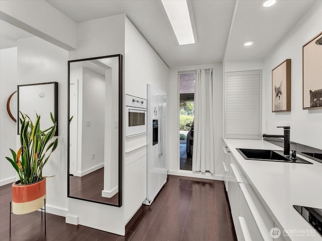 13893 NE 69th St Unit 689, Redmond, WA 98052 - kitchen featuring white cabinets, dark wood-style floors, modern cabinets, recessed lighting, and light countertops