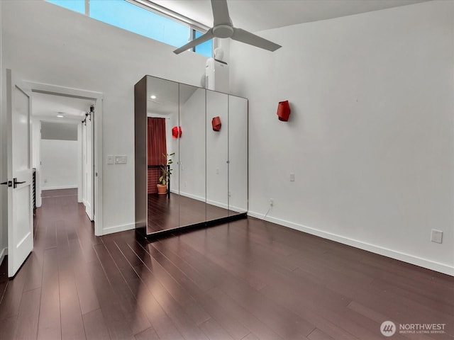 13893 NE 69th St Unit 689, Redmond, WA 98052 - unfurnished bedroom with wood finished floors, a towering ceiling, and ceiling fan