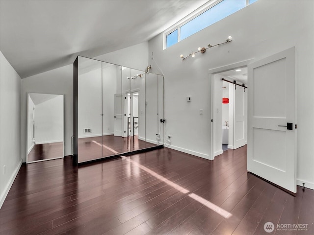 13893 NE 69th St Unit 689, Redmond, WA 98052 - unfurnished bedroom featuring a barn door, wood finished floors, and high vaulted ceiling