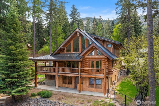 3105 Tamarack Pl, Wenatchee, WA 98801 - back of property featuring log exterior, a patio area, a wooded view, metal roof, and a gate