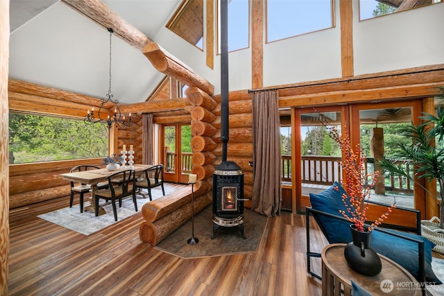 3105 Tamarack Pl, Wenatchee, WA 98801 - dining area featuring log walls, high vaulted ceiling, a wood stove, wood finished floors, and a chandelier