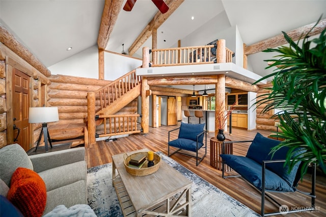 3105 Tamarack Pl, Wenatchee, WA 98801 - living room featuring high vaulted ceiling, rustic walls, stairs, ceiling fan, and wood finished floors