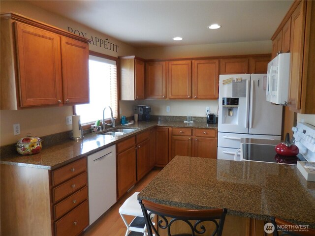 4558 SE Bakken Ct, Port Orchard, WA 98366 - kitchen with white appliances, a sink, brown cabinetry, recessed lighting, and a peninsula