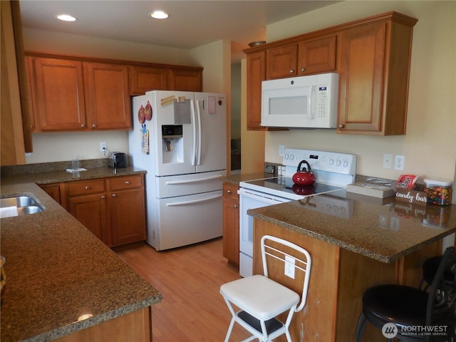 4558 SE Bakken Ct, Port Orchard, WA 98366 - kitchen featuring white appliances, brown cabinetry, light wood-style flooring, a peninsula, and recessed lighting