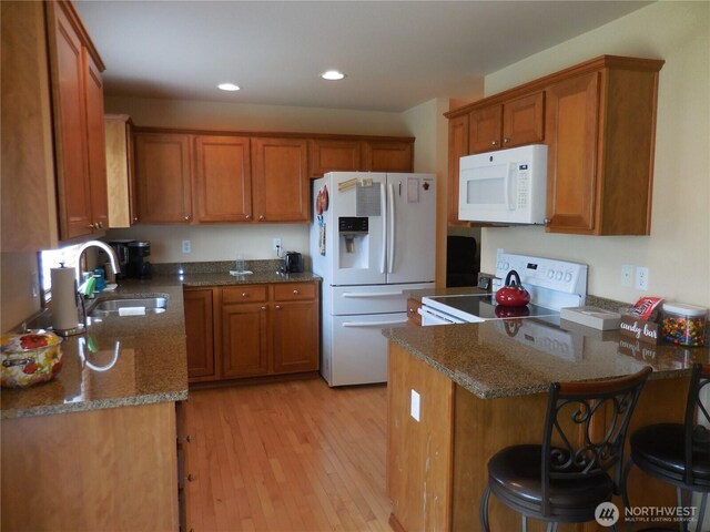 4558 SE Bakken Ct, Port Orchard, WA 98366 - kitchen with white appliances, brown cabinets, a sink, a peninsula, and light wood-type flooring