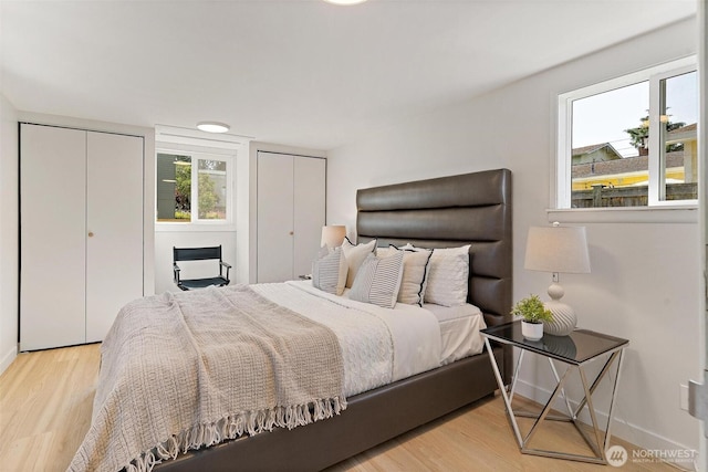 9520 2nd Ave NW, Seattle, WA 98117 - bedroom featuring two closets, wood finished floors, and baseboards