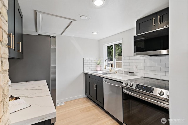 9520 2nd Ave NW, Seattle, WA 98117 - kitchen featuring appliances with stainless steel finishes, a sink, tasteful backsplash, light stone countertops, and recessed lighting