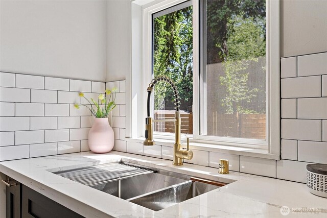 9520 2nd Ave NW, Seattle, WA 98117 - kitchen view of light stone counters, a sink, and decorative backsplash