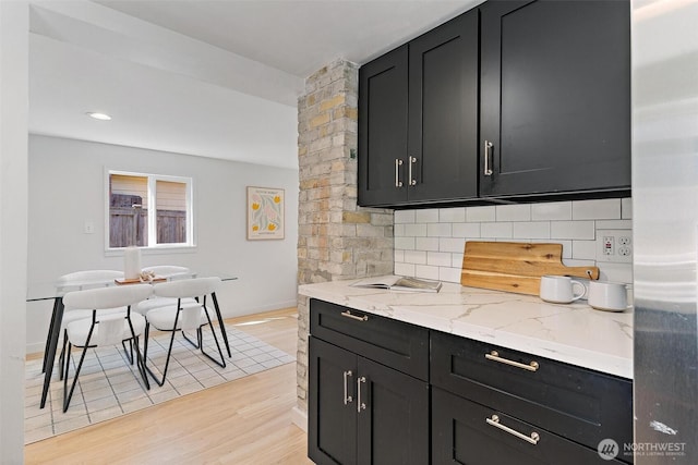 9520 2nd Ave NW, Seattle, WA 98117 - kitchen featuring dark cabinets, stainless steel fridge, decorative backsplash, and light wood finished floors