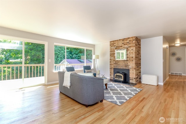 30240 7th Ave S, Federal Way, WA 98003 - living room featuring wood finished floors, a wood stove, healthy amount of natural light, and baseboards