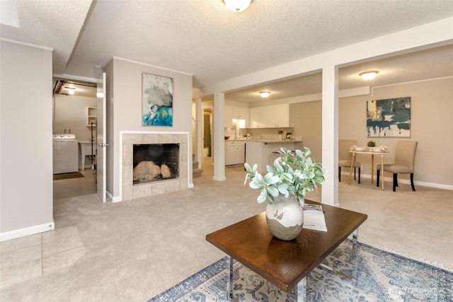 30240 7th Ave S, Federal Way, WA 98003 - living area with light carpet, washer / clothes dryer, a textured ceiling, baseboards, and a fireplace