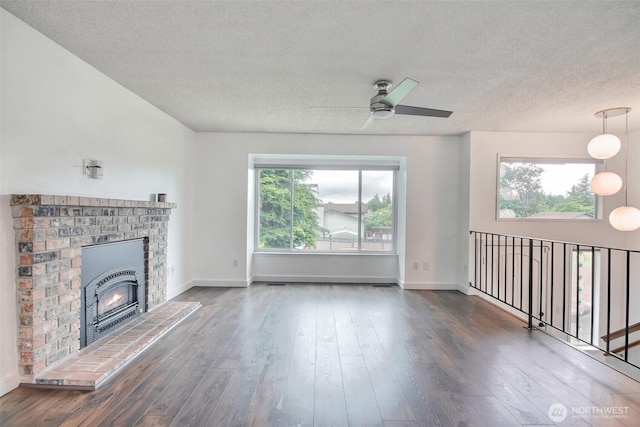 35432 18th Ave SW, Federal Way, WA 98023 - unfurnished living room featuring a textured ceiling, ceiling fan, a brick fireplace, wood finished floors, and baseboards