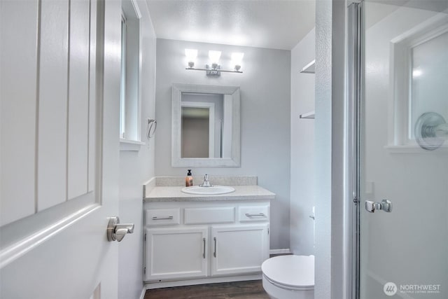 35432 18th Ave SW, Federal Way, WA 98023 - bathroom with toilet, vanity, wood finished floors, and a shower with shower door