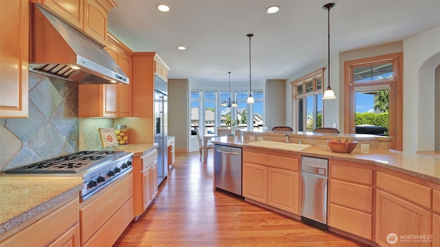 8504 146th Pl SE, Newcastle, WA 98059 - kitchen with under cabinet range hood, appliances with stainless steel finishes, light brown cabinetry, light wood-style floors, and a sink