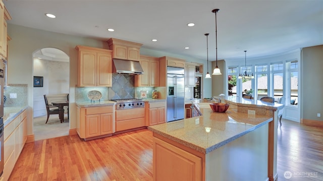 8504 146th Pl SE, Newcastle, WA 98059 - kitchen with appliances with stainless steel finishes, light brown cabinetry, arched walkways, light wood-style floors, and a sink